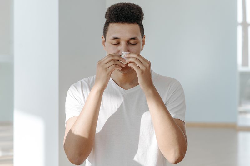 Man wiping nose